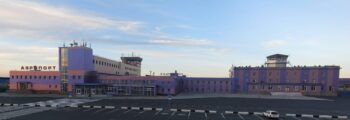 Jet privé : chemin verdoyant menant à un bâtiment blanc.